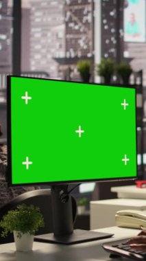 Ofis masasındaki Dikey Video İşkadını, etkili karar verme ve şirket hedeflerini desteklemek amacıyla cihazdaki yeşil ekrana bakıyor, belgeler ve bilgi grafikleri üzerinde çalışıyor. İdari görevler