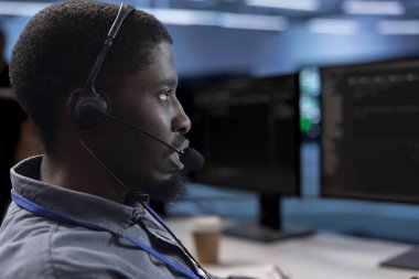 Veri merkezinde bilgi işlem görevlisi kulaklıkla konuşuyor, ekipman kesintilerinden kaçınmak için yıllık check-up yapıyor. Sunucu merkezindeki saha mühendisi ile sohbet eden, sunucuların altyapısını izleyen