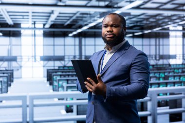 Sunucu odasındaki sistem yöneticisi tablet kullanarak yeni sipariş edilmiş depolama birimleri kuruyor. Veri merkezi depolama tesislerinde çalışan yazılım geliştiricisi