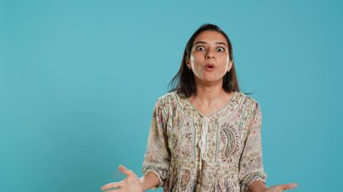 Portrait of joyful indian woman celebrating, showing positive emotions, feeling happy. Delighted person thrilled by achievement, cheering and gesticulating, studio background, camera A clipart