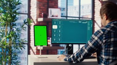 Yeşil ekran tabletinde video üretici modeller için metnin nasıl kullanılacağını öğrenmek isteyen bir adam. Ofisteki adam yapay zeka programı ve B kamerasıyla ilgili video rehberini izliyor.