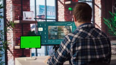 Merkez ofisteki adam yapay zeka programını kullanarak metni izole ekran tabletinin yanındaki videolara dönüştürüyor. Bilgisayar ve krom anahtar aygıtında video üretici modeller için metin kullanan kişi, kamera A