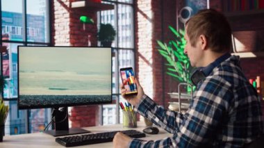 Merkez ofisteki adam çevrimiçi içerik yaratıcılarının canlı yayınlarıyla sosyal medyaya bakıyor. Etkilenenler tarafından yapılan canlı yayınlarla sosyal ağ uygulaması kullanan çalışanlar, kamera A