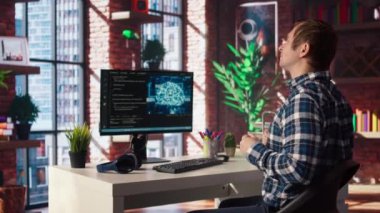 Merkez ofisteki yapay zeka mühendisi bilgisayar ekranına bakarken geriliyor, kodu çalıştırırken yorgun hissediyor. Yapay zeka geliştiricisi sırt ağrısı hissediyor, acıyı hafifletiyor, test kodu, kamera A