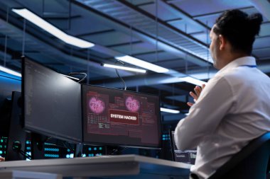 Sunucu merkezindeki sistem yöneticisi donanımı bilgisayar korsanlarının hassas bilgileri çalmasından korumaya çalışıyor. Veri Merkezi güvenlik ihlali sırasında virüsle savaşan siber güvenlik uzmanı