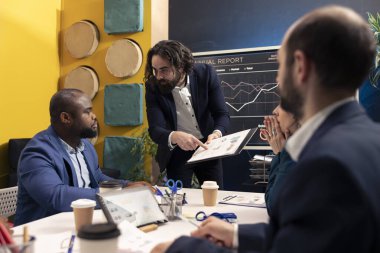 Kurumsal bir konferans sırasında yeni bir projenin iç yüzünü ve detaylarını tartışan bir işletme kuruluşunun çalışanları. Şirket çalışanları pazarlama gelişmeleri hakkında bilgilendiriliyor..
