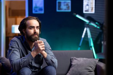 Ev sahibi TV 'yi abonelik temelli yayın yapan romantik filmler izlemek için kullanıyor. Kanepede oturan adam sevgi dolu duygular sergiliyor, TV 'de VOD programlarının keyfini çıkarıyor.