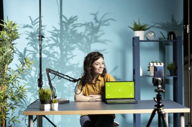 Yeşil ekran dizüstü bilgisayar performansını değerlendiren, bileşenlerden bahseden mutlu teknoloji uzmanı. Neşeli içerik oluşturucu çevrimiçi kanal için maket defteri incelemesi çekiyor, akıllı telefon ile çekim yapıyor