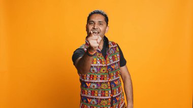 Narsist, neşeli Hintli adamın portresi kutlama ve övünme, kibir gösterme. Başarı, tezahürat ve el kol hareketleri, stüdyo geçmişi ve kamera B ile övünen tatmin olmuş kişi.