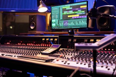 Profesyonel müzik stüdyosundaki kontrol masası motorlu faders ve düğmeleri karıştırma ve usta şarkılarda kullanılıyor. Kayıt ve yapımcılıkta kullanılan boş kontrol odası, ses kabini.