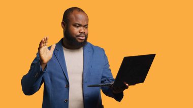 Çalışan, toplantı sırasında iş arkadaşıyla konuşurken el hareketi yapmaz. Dizüstü bilgisayarını, stüdyo geçmişini kullanır. Anlaşmazlık işareti gösteren kişi, video görüşmesi sırasında protesto fikri, kamera A