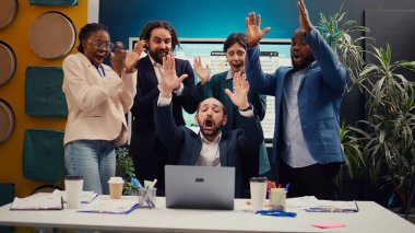 İnternetteki eğilimlere baktıktan sonra proje başarısını kutlayan mutlu iş arkadaşları toplantı odasına atlayıp takımlarıyla gurur duyuyorlar. Yetenekli çalışanlar başarılarının tadını çıkarıyorlar. Kamera B.