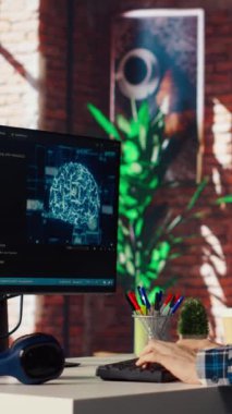 Kendi kendini öğrenme algoritmaları aracılığıyla yapay zeka hesaplaması için bilgisayar kullanan bir programcı. Masaüstü bilgisayarı B kamerasında yapay zeka ile çalışan uzak bir çalışan.