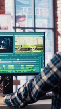 Yaratıcı ev ofisinde renk derecelendirme ve ışıklandırmayı düzenlemeden önce bilgisayar ekranında film montajını analiz eden video editörü. Yapım stüdyosu çalışanı PC, Kamera B 'de ham görüntülerle çalışıyor