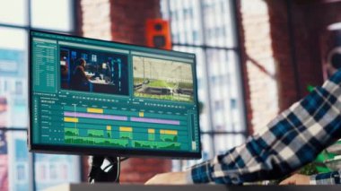 Video editörü film montajını analiz ediyor, renk derecelendirmesini düzenliyor ve yaratıcı ev ofisinde ışıklandırıyor, görüntüyü yakınlaştırıyor. Kaliteyi arttırmak için ham görüntülerle çalışan bir stüdyo çalışanı gönder, kamera B