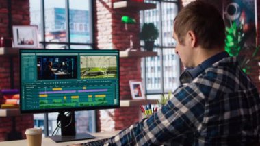 Video düzenleyici video montaj yaparken kullanılacak anahtar çerçeveleri seçiyor, bilgisayarla evden çalışıyor. A numaralı dairede film projesini düzenlemek için fareyi kullanan adam.