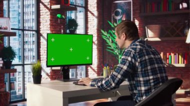 İş ortaklarının e-postalarını cevaplamak için kroma anahtar bilgisayarını kullanarak oturma odasındaki tele-işçi. İzole ekran aygıtı klavyesinde yazan uzaktan çalışan, daire ve kamera A 'daki görevleri çözen