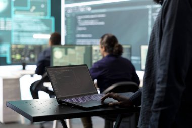 Hükümetin bilişim uzmanı büyük ekran ve dizüstü bilgisayardaki siber tehditleri inceliyor, yüksek teknoloji ajansındaki veri tabanına sızma faaliyetlerini yönetiyor. Devlet sırlarını ve ağlarını korumak için siber savunma üzerinde çalış.