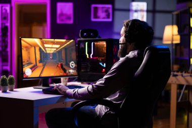 FPS video oyunu oynayan, karanlık, rahat bir dairede eğlenen bir adam. Oyun meraklısı PVP online çok oyunculu oyunda yarışıyor, gelecekteki lazer mermilerle diğer oyuncuları vuruyor