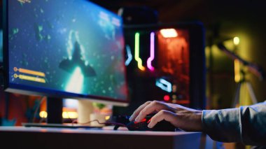 Bir adamın oyun rgb ışıklandırmalı fareyi kullanarak eğlenceli bir video oyunu oynayıp galakside uzay gemisi uçurduğunu yakın plan çek. Profesyonel oyuncu, bilim kurgu oyunundan zevk almak için profesyonel bilgisayar çevresi kullanıyor