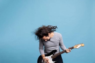 Hevesli rockçı, rock 'n roll' a tutkuyla ve neşeyle siyah elektro gitar çalıyor. Uzun saçlı, dinamik, modaya uygun sanatçı stüdyoya hareket, eğlence ve eğlence getiriyor..