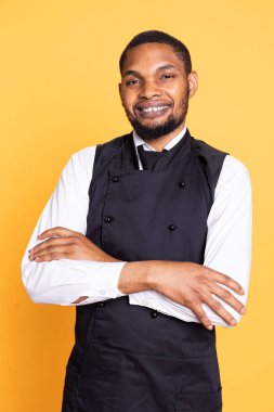 Profesyonel üniforma ve önlük giyen garson portresi müşterilere yardım ve hizmet için hazırlanıyor. Müşteri memnuniyeti için hizmet odaklı çevrede çalışan çalışanlar.