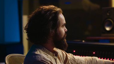 Yeni müzik albümünü kaydetmek ve düzenlemek, sesleri işlemek ve kontrol odasında karıştırma konsolu kullanmak üzerine çalışan bir ses uzmanı. Profesyonel stüdyoda düğmelere basan bir teknisyen. Kamera A.