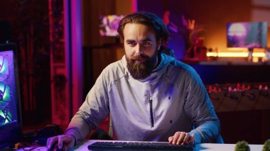 İçerik yaratıcı, neon ışıklı daireden çevrimiçi izleyicilerle sohbet ederken canlı video oyunları oynuyor. İzleyicilerle stratejilerini tartışırken çok oyunculu profesyonel oyuncu oyunu