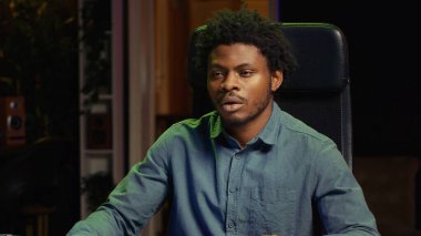 BIPOC oyuncusu canlı yayın sırasında video oyunları oynarken izleyicilerle tartışıyor. Seyircilerle sohbet eden, spor turnuvalarında zafer kazanmanın yollarını sunan bir medya yıldızı.