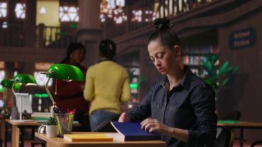 Bir halk kütüphanesinde akademik kaynaklar ve başarı için rehberlik üzerine çalışan profesyonel yazar ve kütüphaneci. Eğitici bilgi toplayan bir kadın. Kamera B.