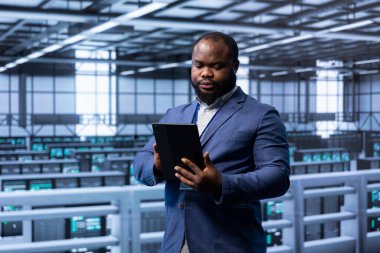 Sunucu odasındaki yönetici yeni sipariş edilen depolama birimlerini cihaz kullanarak kuruyor. Bilgi Merkezi iş yerinde çalışan bilişim uzmanı konut depolama düzeneği donanımını düzenliyor