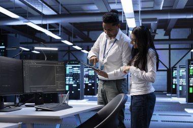 Veri merkezindeki ekip teknisyenleri sunucuları etkileyen güvenlik duvarı yapılandırmalarını arıyorlar. Sunucu odasındaki işçiler, veri aktarım oranlarının düşmesine yol açan sistem darboğazlarını kontrol ediyorlar