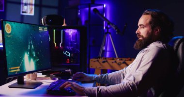 Adam SF video oyununda uzay gemisini uçurmak için klavye kullanıyor. Çevrimiçi bilim kurgu çok oyunculu oyun yarışmasında güçlü PC ve bilgisayar kenarlarını kullanan oyuncu