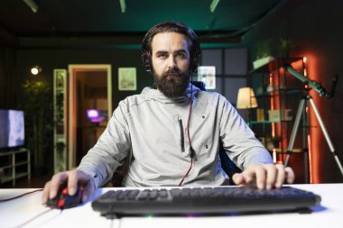 Profesyonel oyuncu arkadaşlarıyla yoğun online çok oyunculu video oyununda rakip oluyor, oturma odasından düşmanlarını rgb lambalarıyla vuruyor. Oyun bilgisayarı ve kulaklık kullanan adamın POV 'u