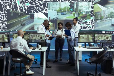 Diverse group of agency employees studying order logistics in control center, monitoring the delivery trucks activity via satellite navigation. Operators working with gps coordinates for tracking. clipart