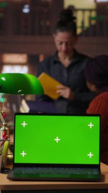 Dikey video çeşitliliği olan liseli kızlar, profesörlerle birlikte bir okul kütüphanesinde kompozisyon yazmaya odaklanmış, model ekranın yanında ev ödevi üzerinde çalışıyorlar. Bilginler ders kitaplarındaki ödevlerini tamamlıyorlar. Kamera B.