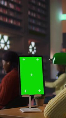 Bir kütüphanede krom anahtarın yanına ders notları yazan dikey Afrikalı Amerikalı liseli kız, bir okul projesi üzerinde çalışıyor ve tablet hakkında internet bilgisi var. Öğrenci ders ve kursa hazırlanıyor.