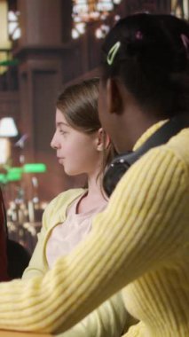 Dikey Video Afrikalı Amerikalı özel öğretmen çeşitli liseli kızlara destek veriyor, kütüphane masasındaki ders planında onlara rehberlik ediyor. Öğretmen öğrenim materyalleri sağlıyor, akademisyenlere danışmanlık yapıyor.