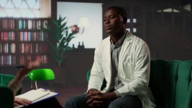 Siyahi doktorlarla terapi seansında, hastalarını kaybettikten sonra travma geçiren, stres bozukluğu ve anksiyeteyi tartışan profesyonel danışman. Psikolojik sağlık ve destek sistemi. Kamera B.