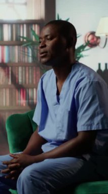 Dikey video hemşiresi terapi seansında otururken duygusal stres yaşıyor. Siyahi sağlık uzmanları, mesleki riskleri yüzünden zihinsel sağlık sorunlarıyla ilgileniyorlar. Hastanın travması