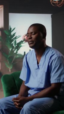 Dikey video hemşiresi terapi seansında otururken duygusal stres yaşıyor. Siyahi sağlık uzmanları, mesleki riskleri yüzünden zihinsel sağlık sorunlarıyla ilgileniyorlar. Hastanın travması