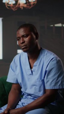 İş kaygısından ve travma sonrası stres bozukluğundan kurtulmak için erkek hemşireyi destekleyen dikey video danışmanı, sağlık kariyeri içinde terapi seansı. Duygusal stres ve kaybedilen hastaların stresi tartışıldı. Kamera A