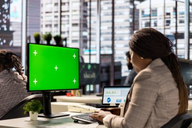 Çalışma alanında oturan kadın yönetici, stratejik iş hedefleri ve karar verme süreçlerini desteklemek için mali raporları analiz ediyor..