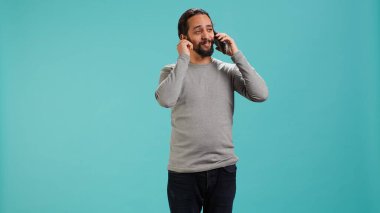Olumlu duyguları olan neşeli bir adam telefon görüşmesinde arkadaşlarıyla konuşmaktan zevk alıyor. Akıllı telefon, stüdyo geçmişi. Yüzünde gülümseme olan mutlu bir insan, telefon görüşmesi sırasında iyi haberler alıyor, kamera A