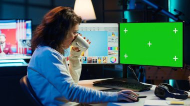 İçerik uzmanı, reklam şirketi için yeşil ekran bilgisayarında sosyal medya paylaşımı yapmak için grafik tasarım becerileri kullanır. Promosyon görüntüsü oluşturmak için krom anahtar PC monitörü kullanan fotoğraf editörü, kamera A