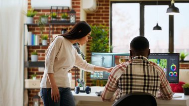 Video düzenleme sürecinde işbirliği yapan yaratıcı ırklar arası çift profesyonel yazılım ve renk çarkını kullanmanın birçok yolunu tartışıyor. Memlekette çok ırklı kadın ve erkekler var. Kamera B.