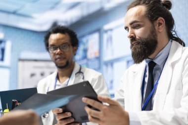 Toplantıda, doktorlar ve tıbbi personel röntgen taramalarına ve test sonuçlarına odaklanarak tanı koyuyor. Lisanslı uzmanlıkları, tedavi planları ve hastalıkların önlenmesine rehberlik etmektedir..