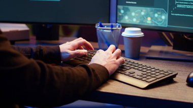 Graffiti 'de klavyede hızlı yazan hackerlar saklanma yerini boyadı, casus yazılım geliştirme yazılımını bitirmek için acele ediyor, kullanıcı bilgisayarlarından bilgileri toplamak için kullanıyor, kamera B' yi kapatıyor.