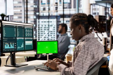 Kadın yönetici krom anahtar ekranın yanındaki finansal planlamaya odaklanarak veri analizi ve şirket stratejisi için bilgi grafiklerini gözden geçirdi. İş kadını büyümeye yönelik girişimsel çözümler sunuyor.