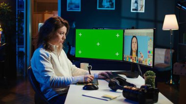 Moda dergisi için profesyonel kamerayla çekilmiş editör resimlerine bakmak için yeşil ekran monitörü kullanan fotoğraf editörü. Freelancer, grafik tablet, kamera B kullanarak, Mokup PC üzerindeki resimleri tarıyor